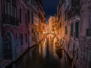 Venice night with Gondola and bridge on canal with night lights and houses